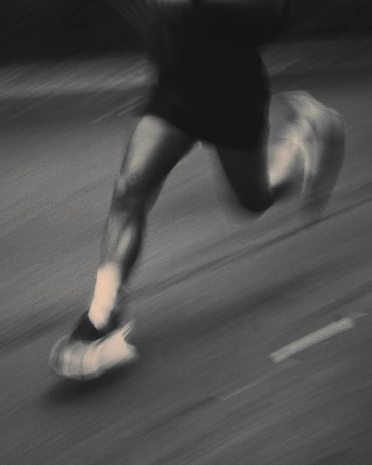A runner’s legs blurred by speed on the road